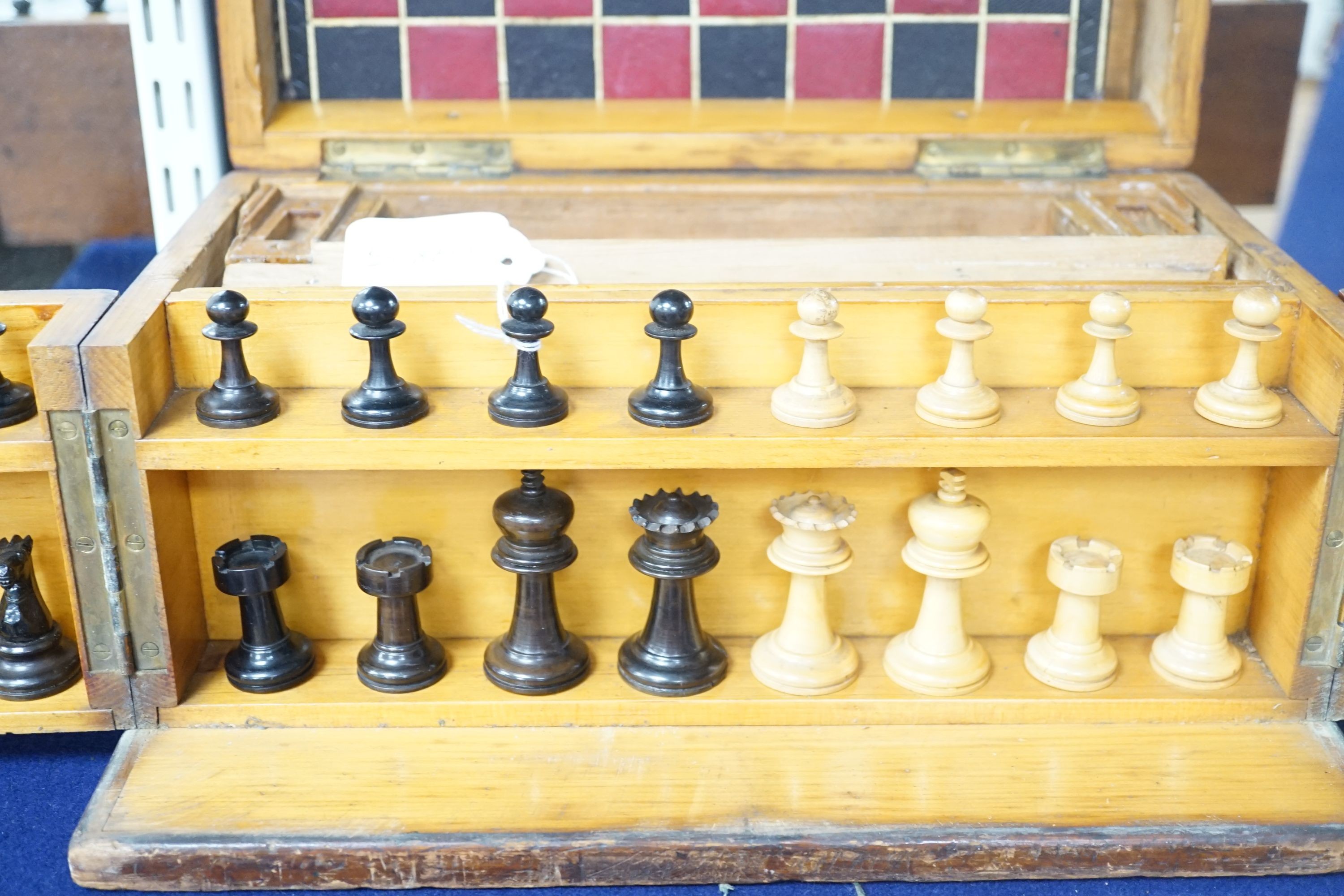 A 19th century mahogany games compendium with turned wood chess pieces and lead jockey and horse pieces